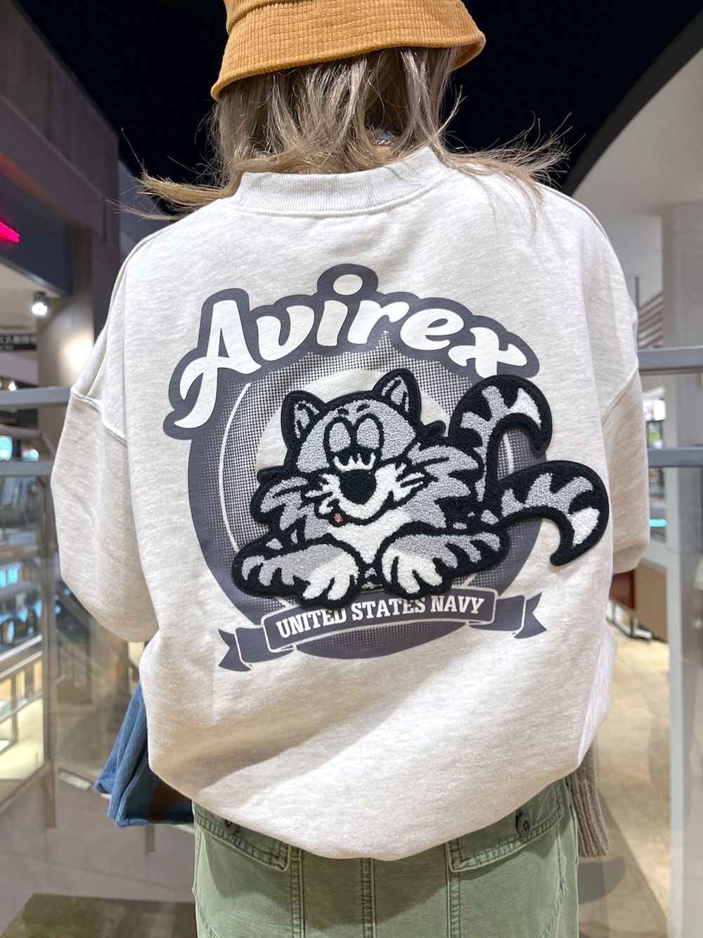 ベージュ系のスウェット、ブルー系のトートバッグ、ブラウン系のカーディガン/ボレロを着用したレディースの冬コーディネートの3枚目の写真