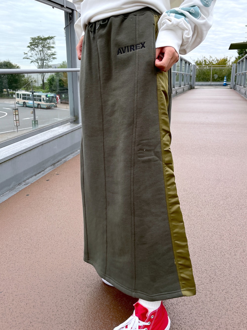 ホワイト系のスウェット、グリーン系のスカートを着用したレディースの秋コーディネートの3枚目の写真