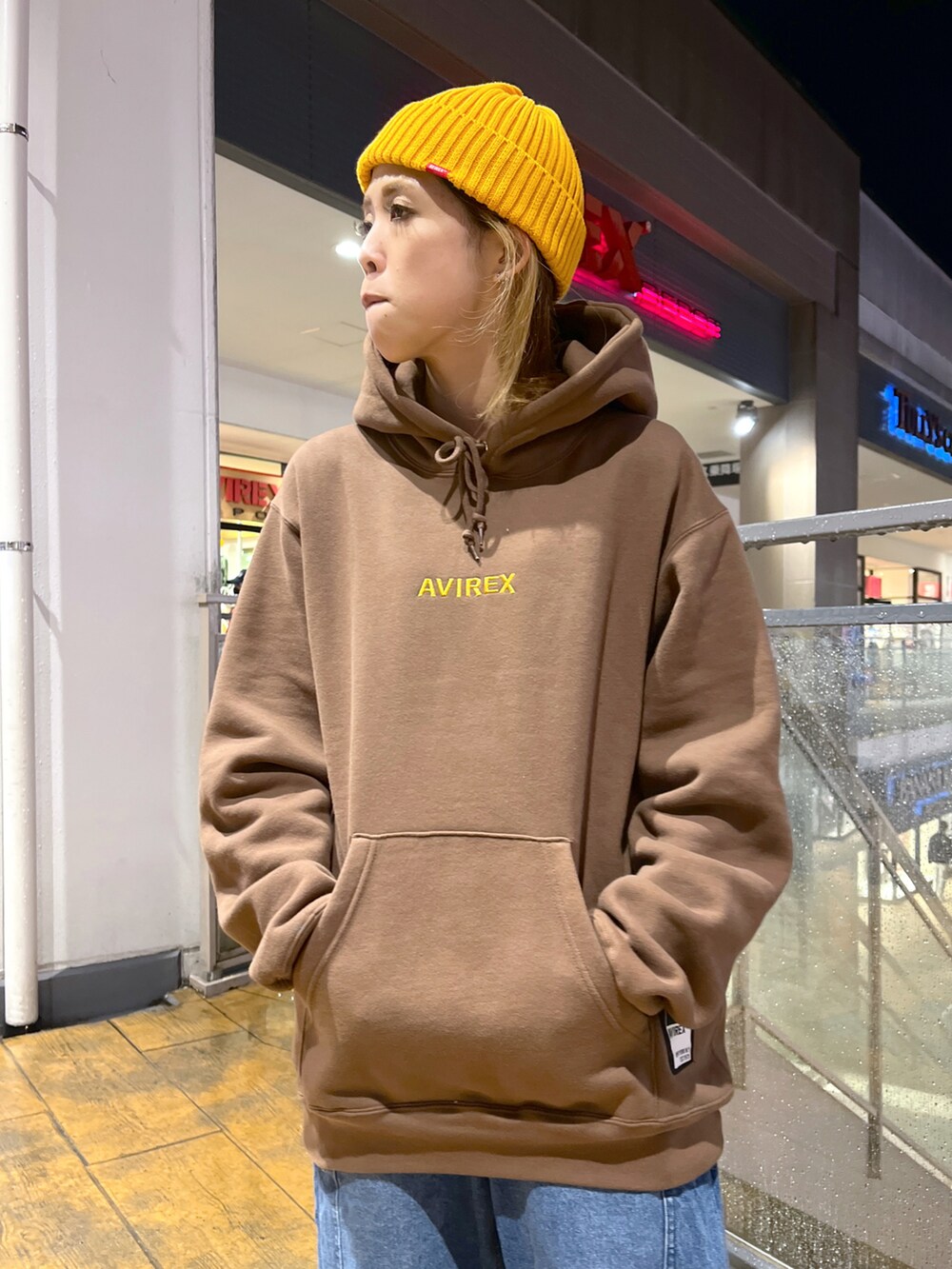 ブラウン系のパーカー、ブルー系のカーゴパンツ、イエロー系のニットキャップ/ビーニーを着用したレディースの秋コーディネートの3枚目の写真