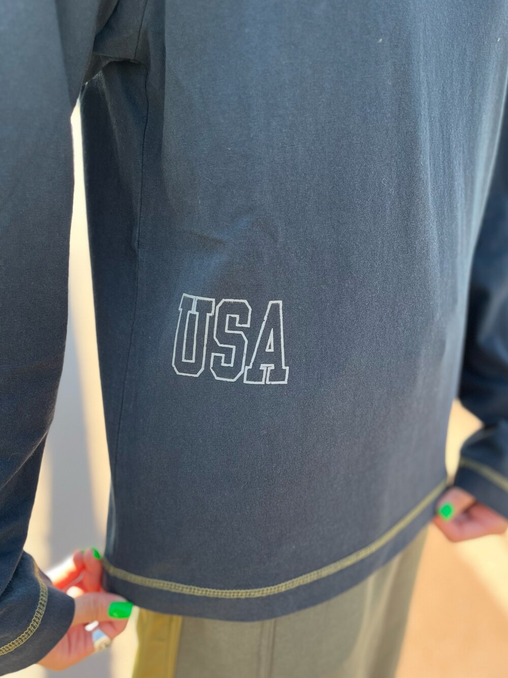 グリーン系のスカート、ブラック系のTシャツ/カットソーを着用したレディースの秋コーディネートの3枚目の写真