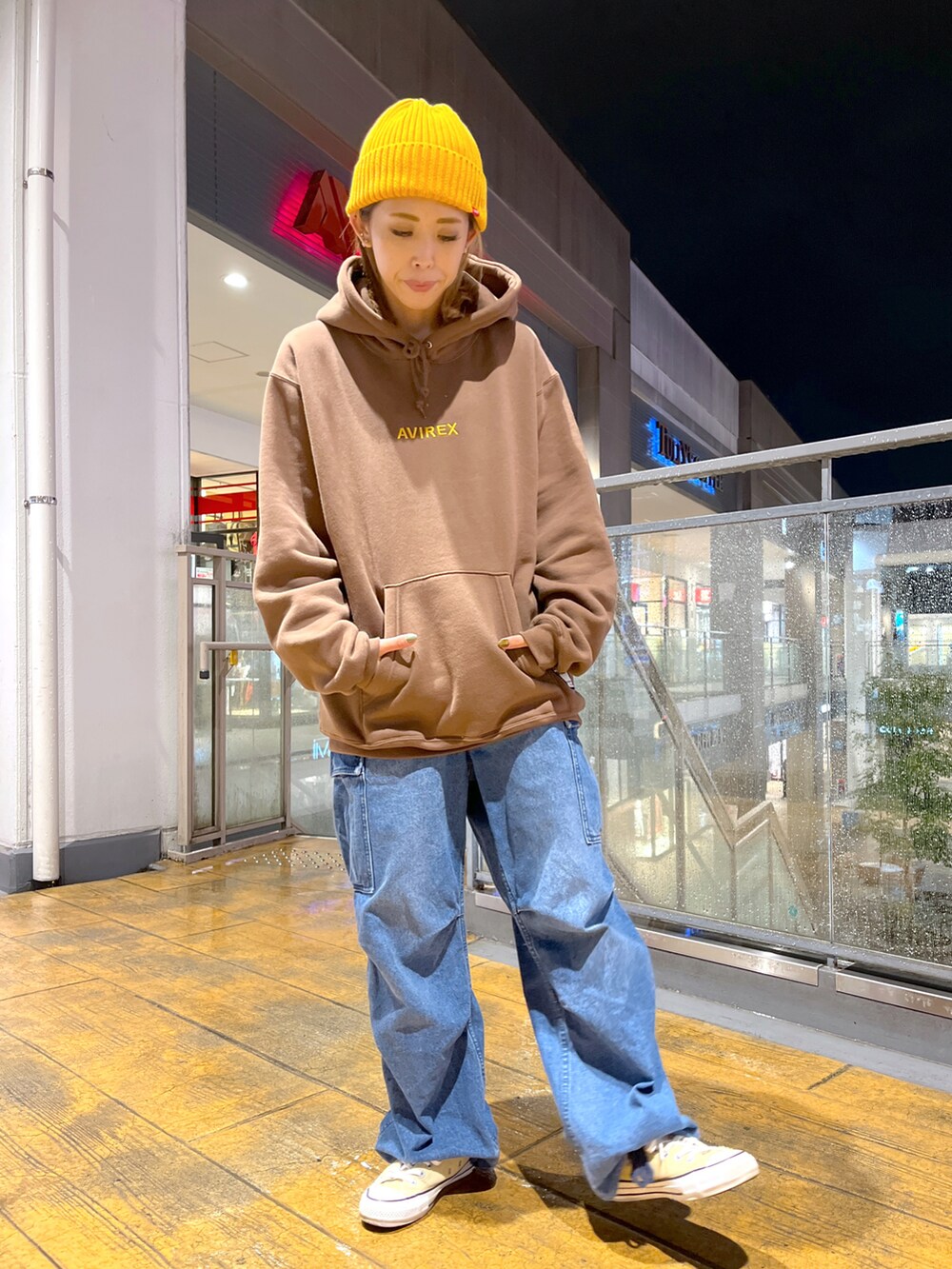 ブラウン系のパーカー、ブルー系のカーゴパンツ、イエロー系のニットキャップ/ビーニーを着用したレディースの秋コーディネートの2枚目の写真