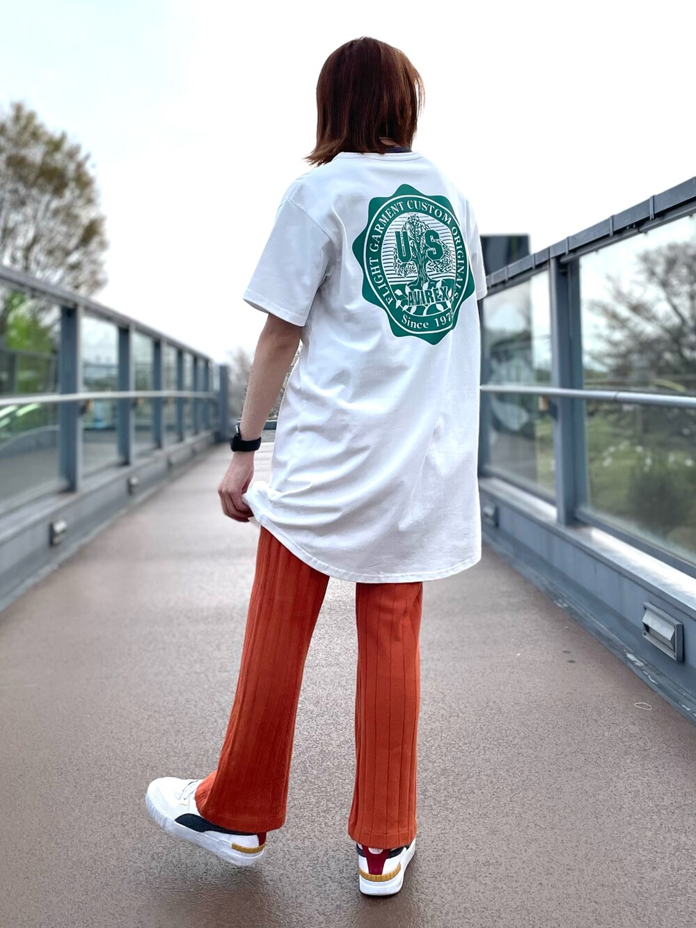 ホワイト系のワンピース、オレンジ系のその他パンツを着用したレディースの春コーディネートの2枚目の写真