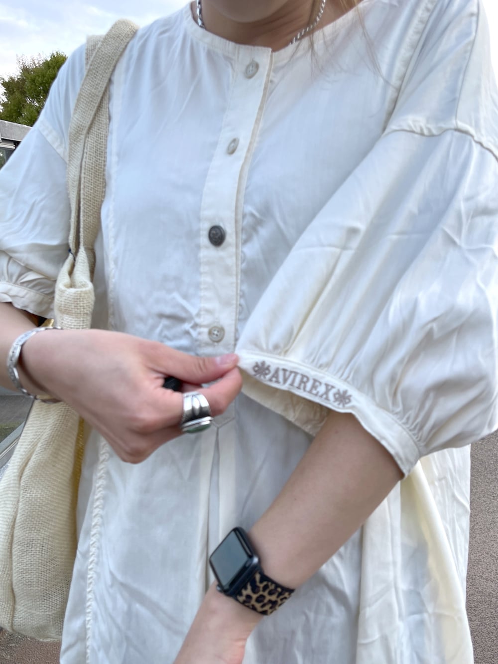 ホワイト系のワンピース、ベージュ系のトートバッグを着用したレディースの春コーディネートの3枚目の写真