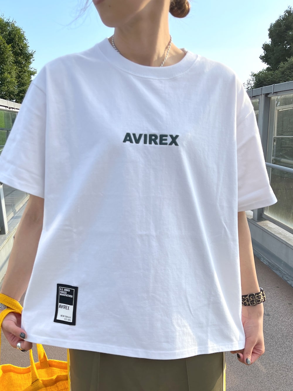 ホワイト系のTシャツ/カットソー、グリーン系のスカート、イエロー系のトートバッグを着用したレディースの夏コーディネートの2枚目の写真