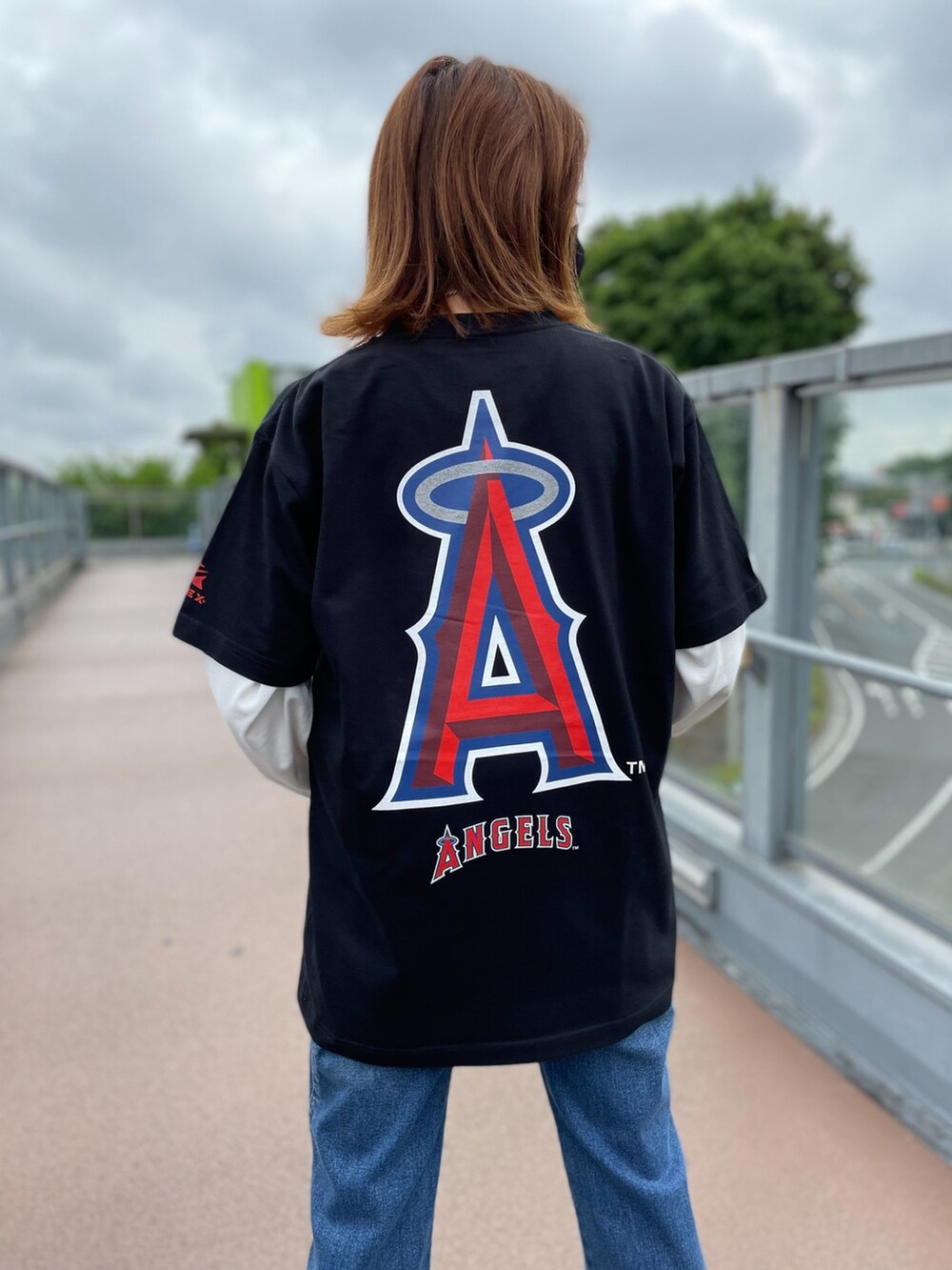 ブルー系のデニムパンツ、ホワイト系のTシャツ/カットソー、ブラック系のTシャツ/カットソーを着用したレディースの春コーディネートの2枚目の写真