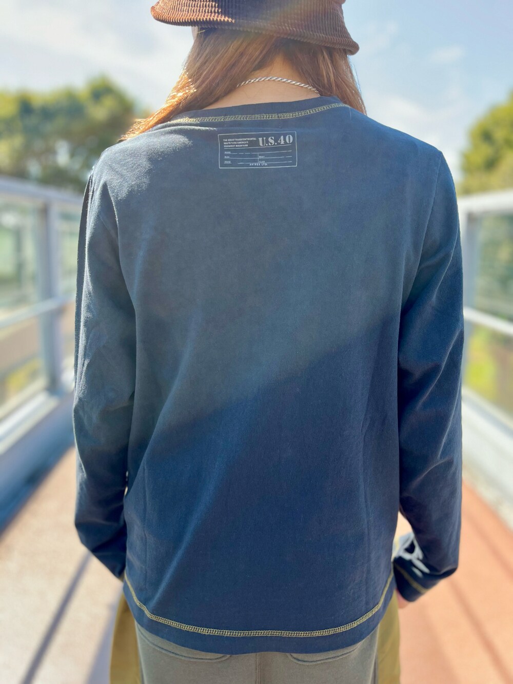 グリーン系のスカート、ブラック系のTシャツ/カットソーを着用したレディースの秋コーディネートの4枚目の写真