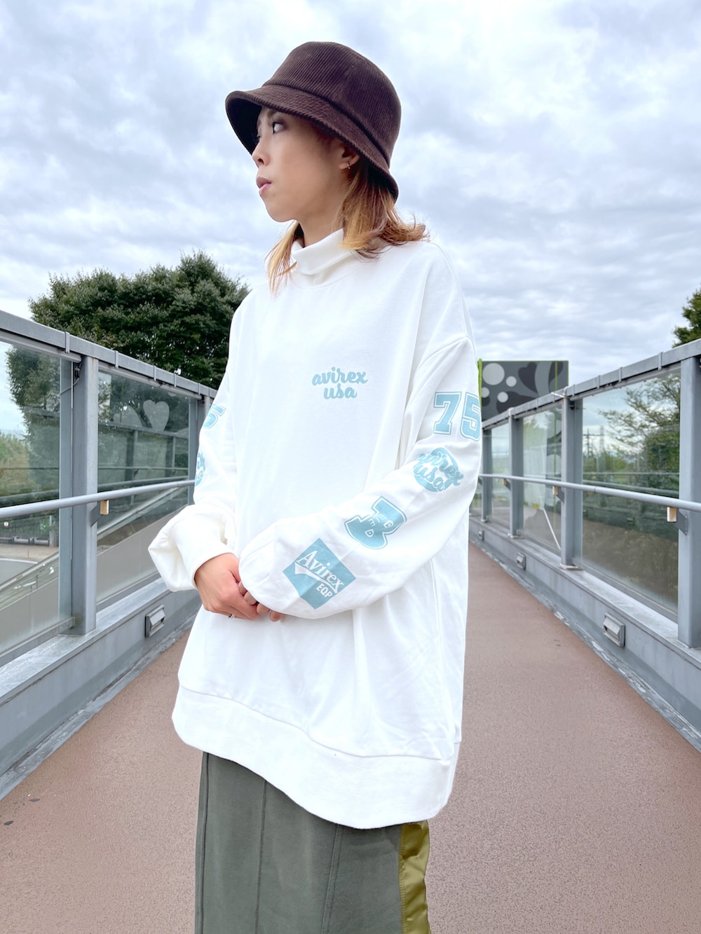 ホワイト系のスウェット、グリーン系のスカートを着用したレディースの秋コーディネートの2枚目の写真