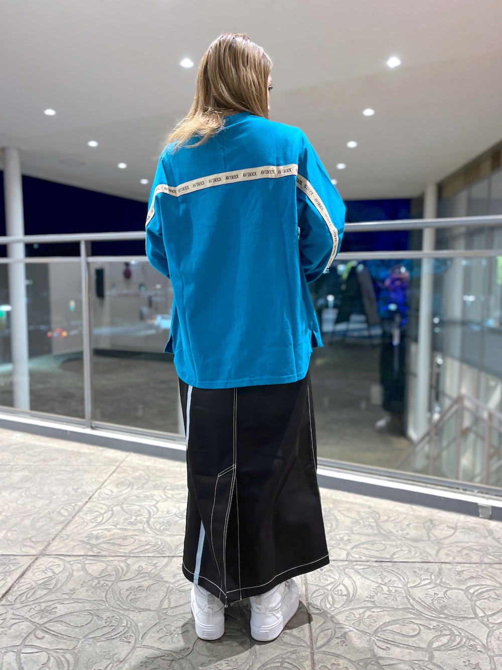 グリーン系のTシャツ/カットソー、ブラック系のスカート、グレー系のショルダーバッグを着用したレディースの冬コーディネートの2枚目の写真