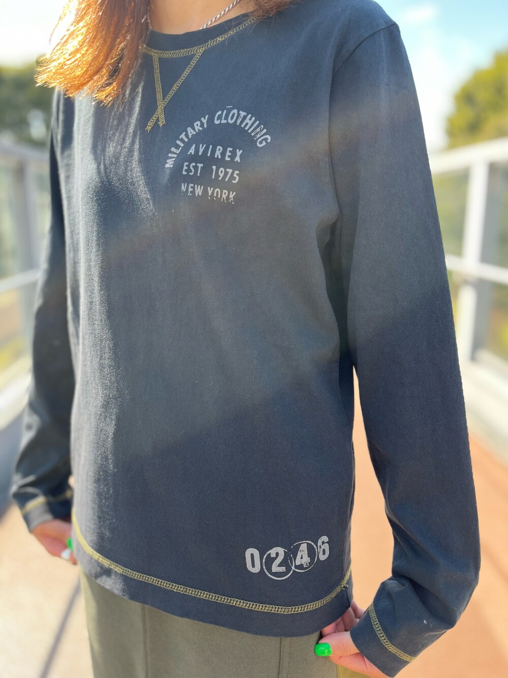 グリーン系のスカート、ブラック系のTシャツ/カットソーを着用したレディースの秋コーディネートの2枚目の写真