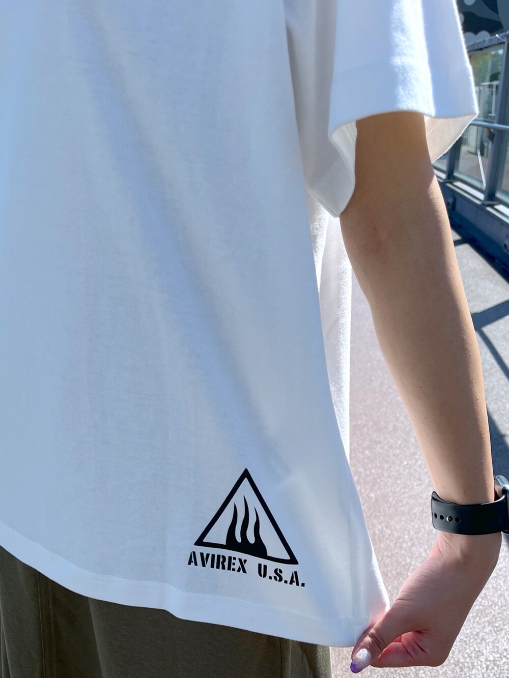 グリーン系のスカート、ホワイト系のTシャツ/カットソーを着用したレディースの夏コーディネートの3枚目の写真