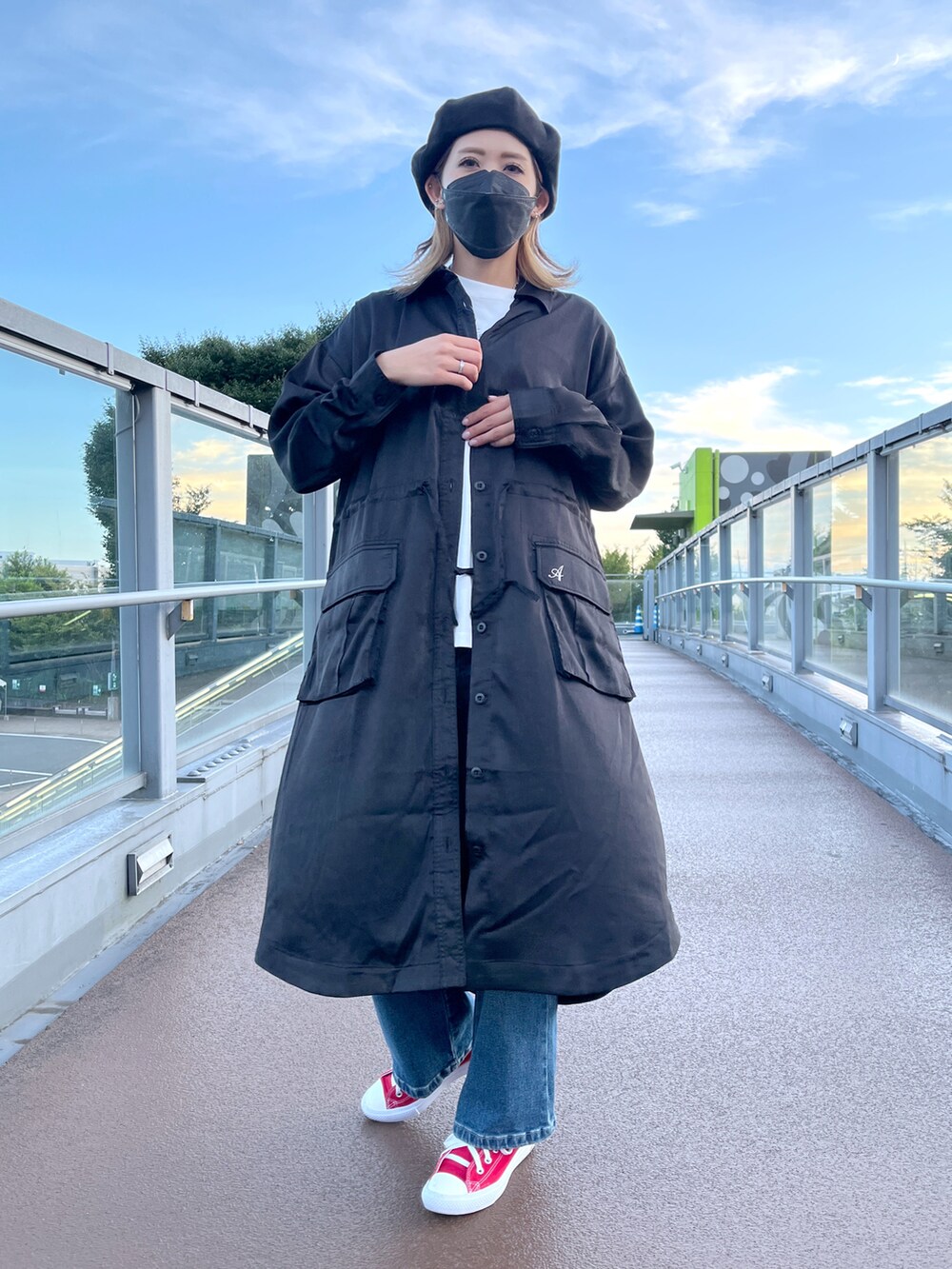 ブルー系のデニムパンツ、ホワイト系のTシャツ/カットソー、ブラック系のシャツワンピースを着用したレディースの秋コーディネートの3枚目の写真