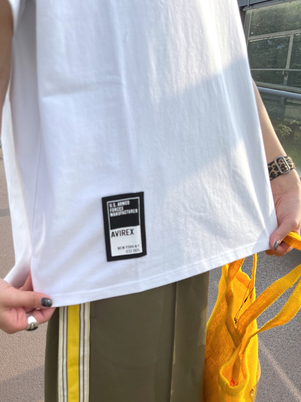 ホワイト系のTシャツ/カットソー、グリーン系のスカート、イエロー系のトートバッグを着用したレディースの夏コーディネートの3枚目の写真