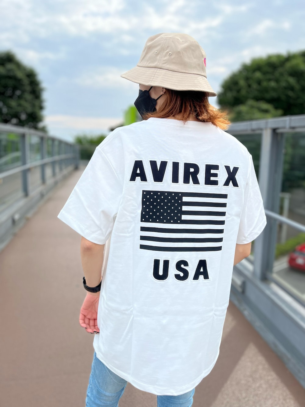 ブルー系のTシャツ/カットソー、ブルー系のデニムパンツ、ベージュ系のハットを着用したレディースの夏コーディネートの2枚目の写真