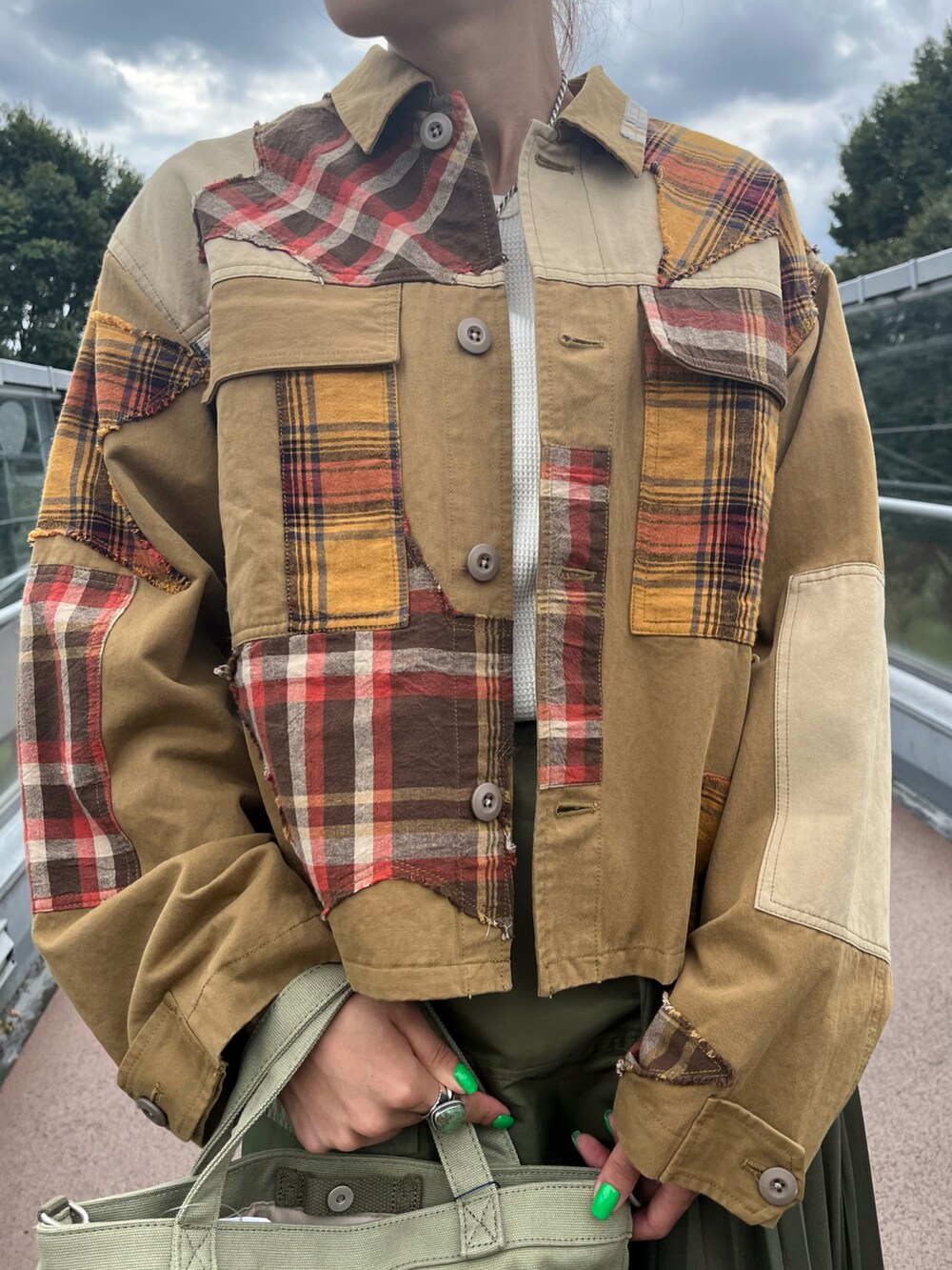 ベージュ系のその他アウター、グリーン系のスカート、ホワイト系のTシャツ/カットソーを着用したレディースの秋コーディネートの3枚目の写真