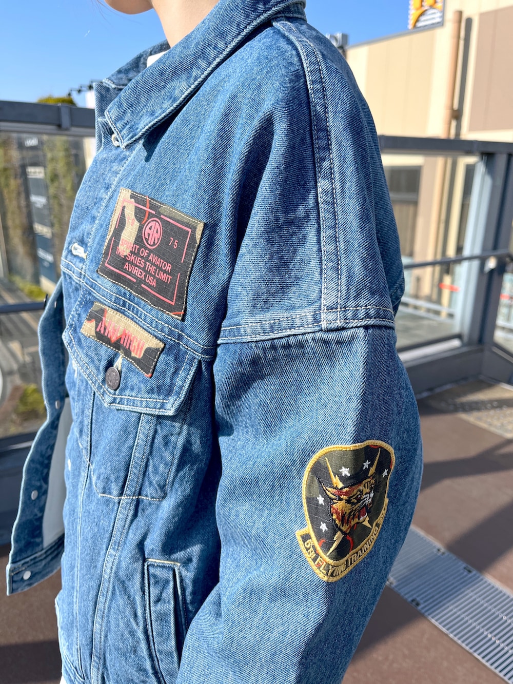 ブルー系のデニムジャケット、ホワイト系のTシャツ/カットソー、ブラウン系のスカートを着用したレディースの春コーディネートの4枚目の写真