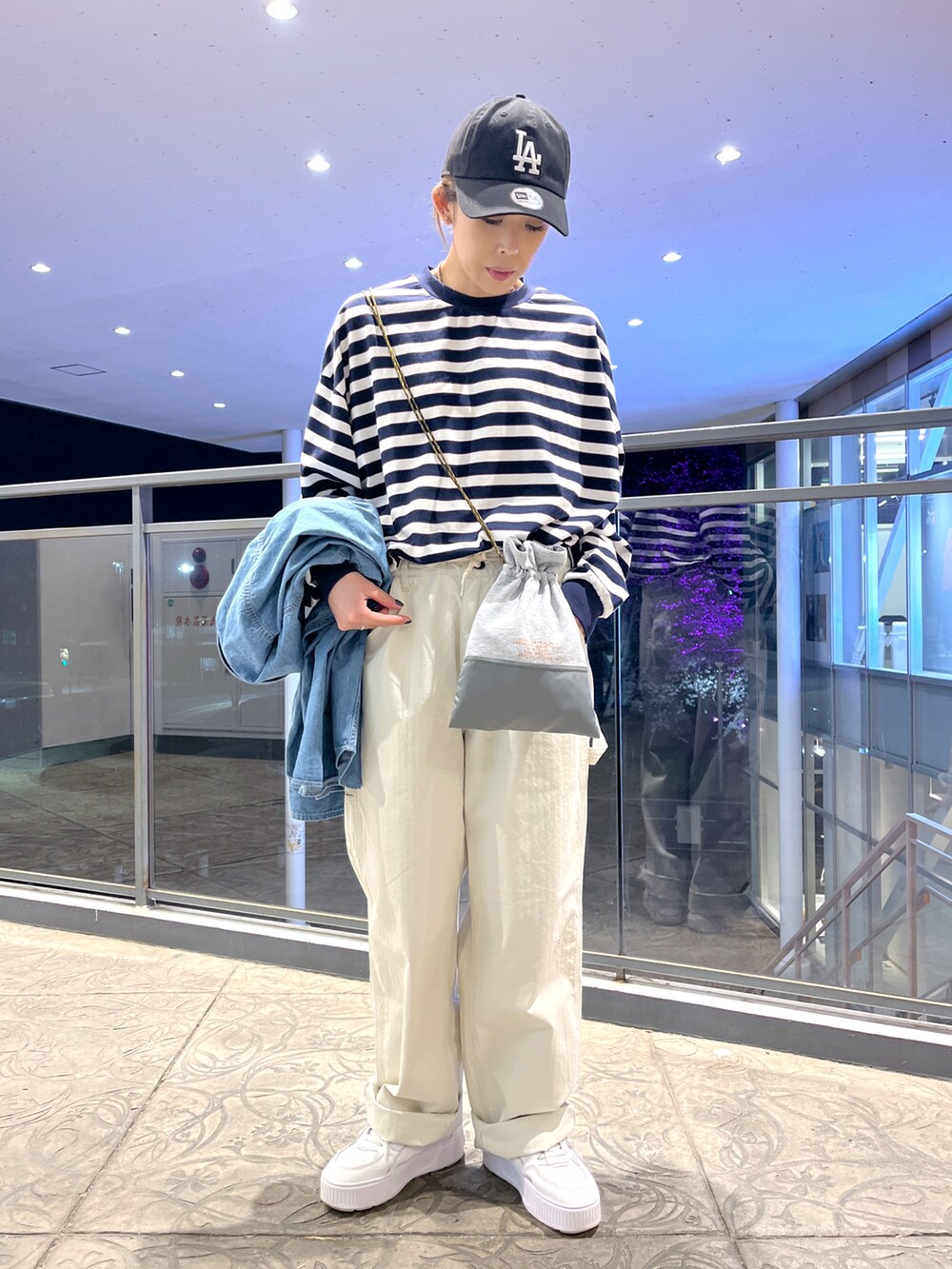 ブルー系のTシャツ/カットソー、ホワイト系のその他パンツ、グレー系のショルダーバッグを着用したレディースの春コーディネートの2枚目の写真