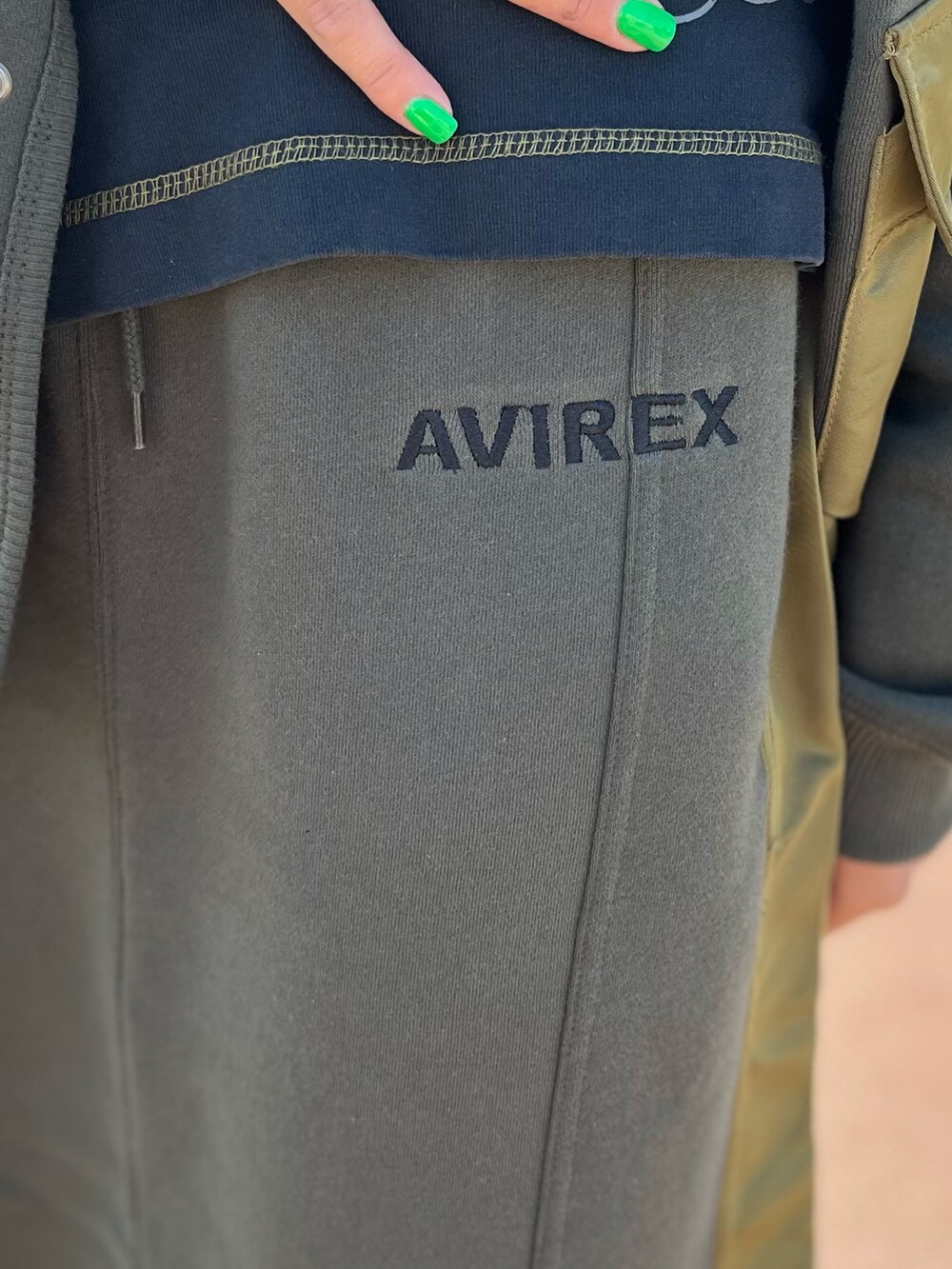 グリーン系のスカート、ブラック系のTシャツ/カットソーを着用したレディースの秋コーディネートの5枚目の写真