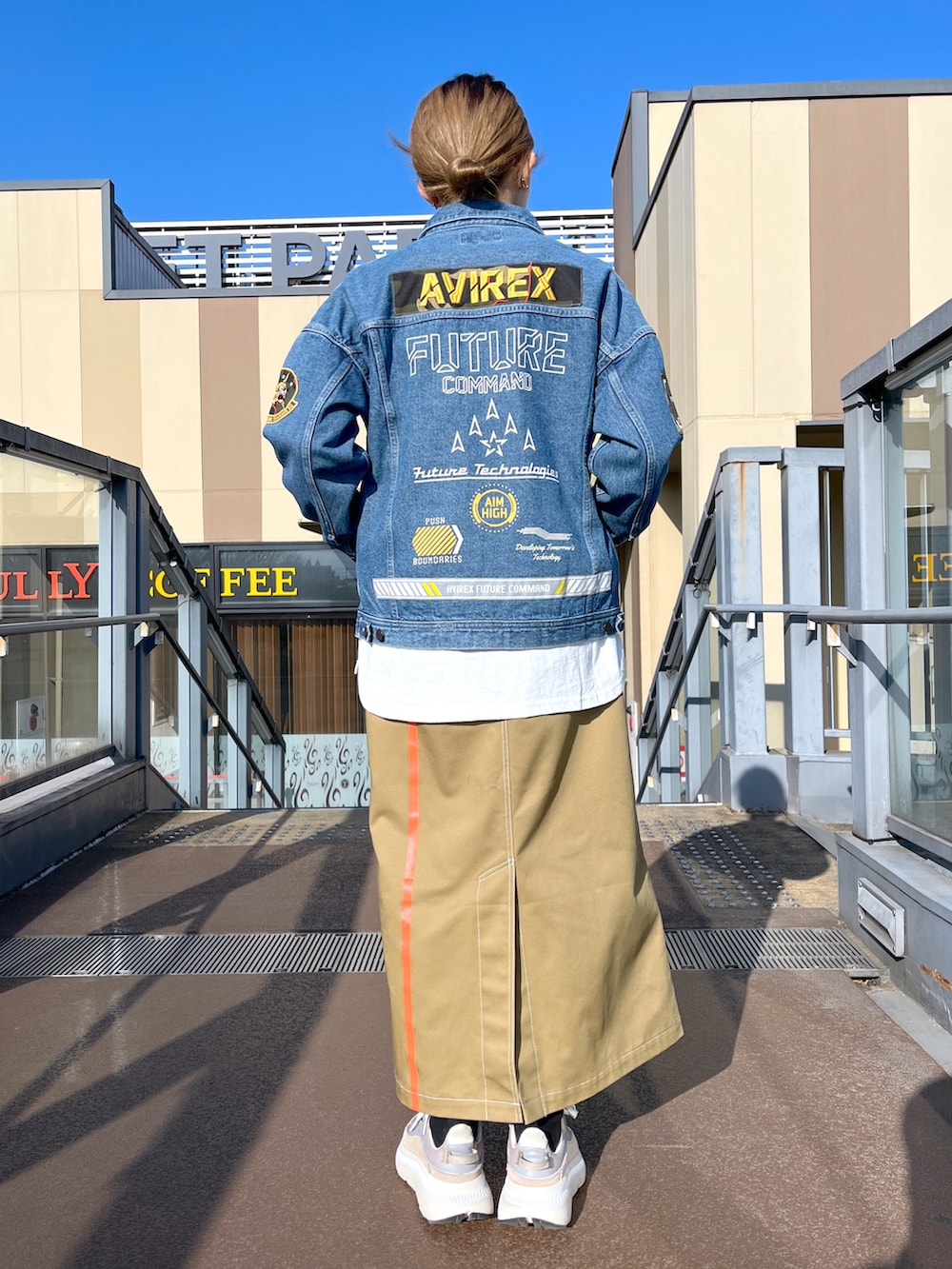 ブルー系のデニムジャケット、ホワイト系のTシャツ/カットソー、ブラウン系のスカートを着用したレディースの春コーディネートの2枚目の写真