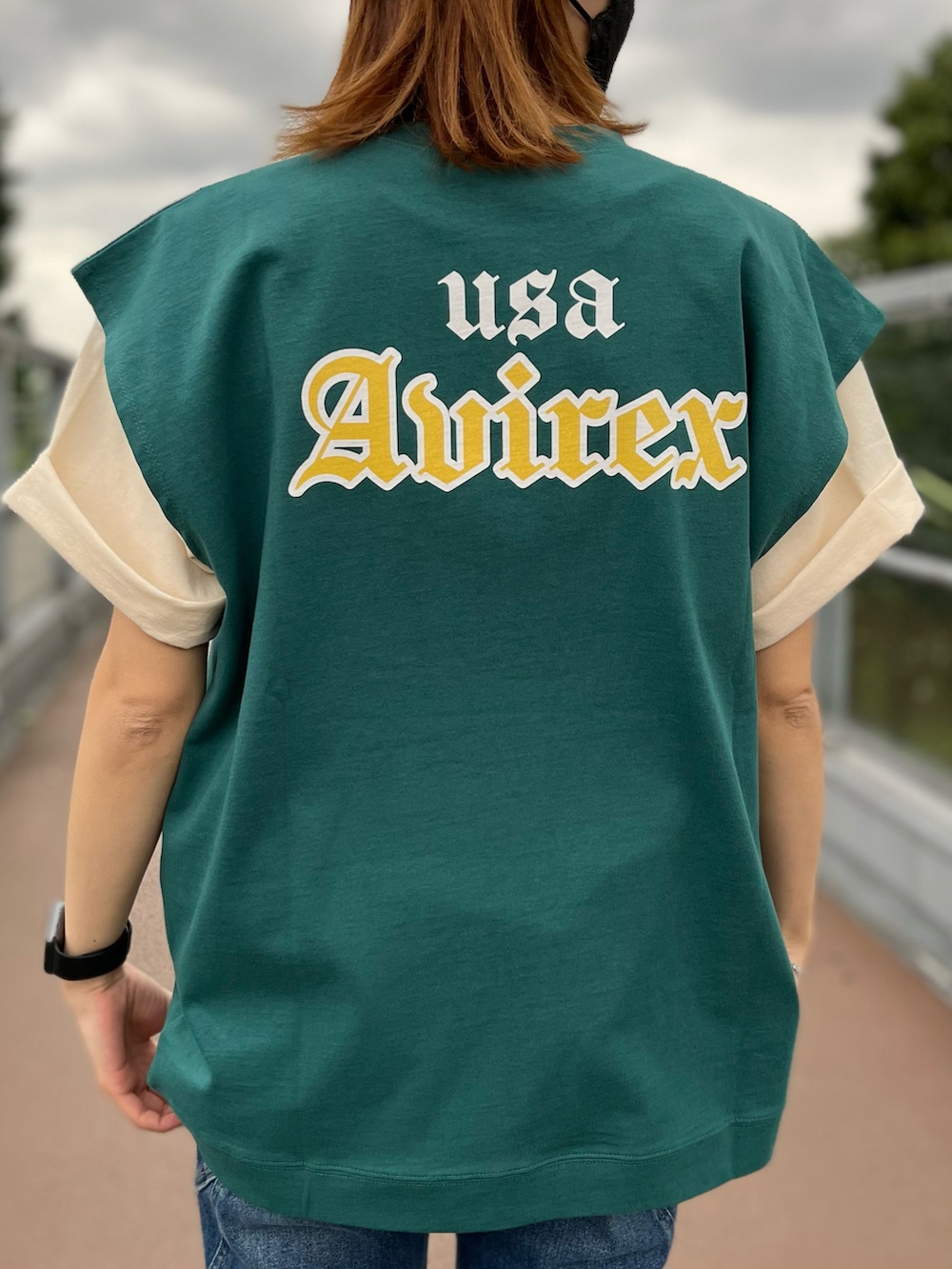 グリーン系のタンクトップ、ホワイト系のTシャツ/カットソー、ブルー系のデニムパンツを着用したレディースの夏コーディネートの2枚目の写真