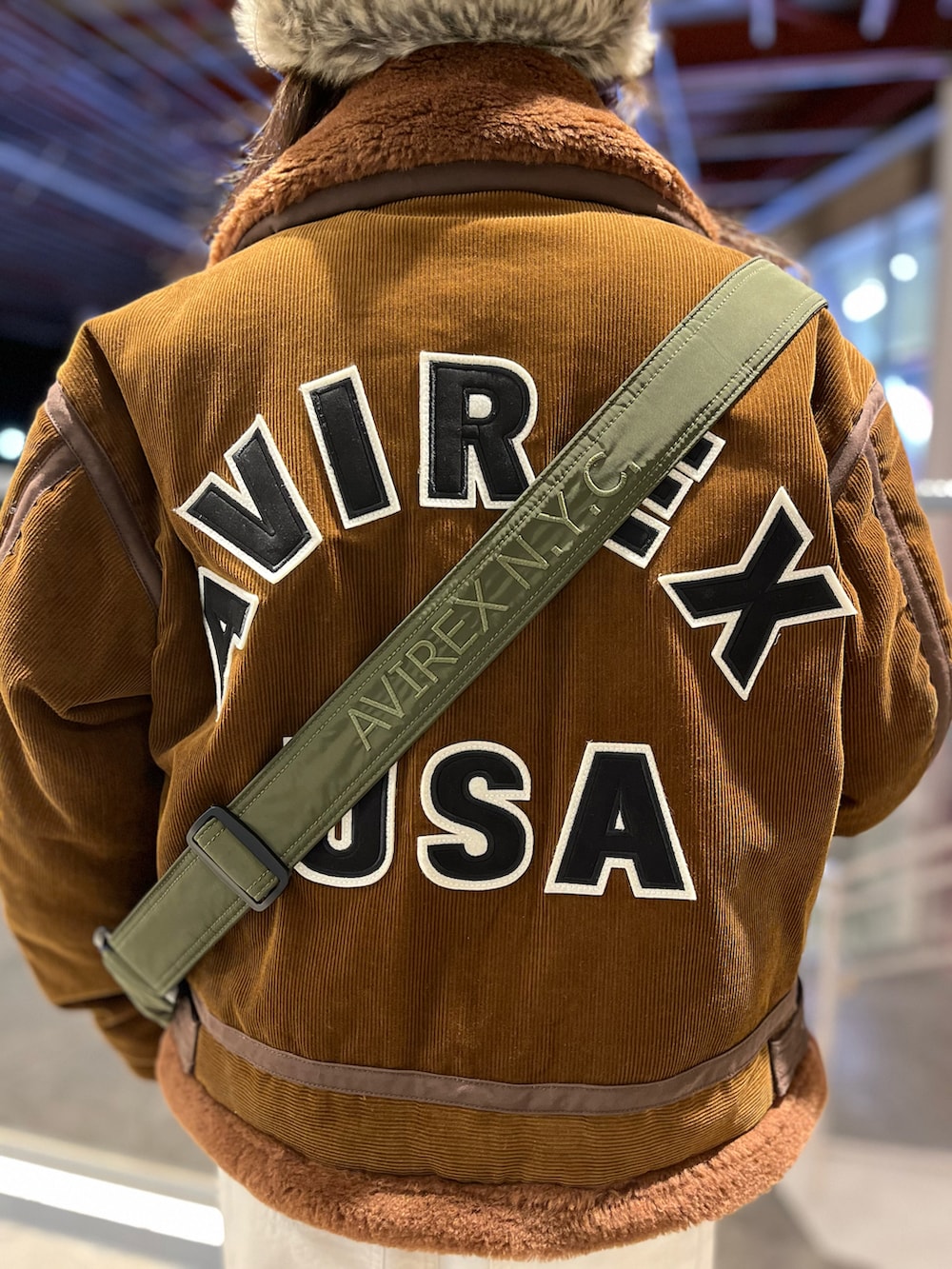 ブラウン系のミリタリージャケット、ベージュ系のスウェット、グリーン系のショルダーバッグを着用したレディースの冬コーディネートの3枚目の写真