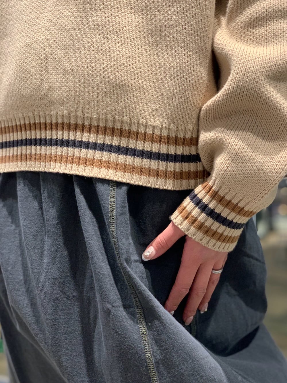 ベージュ系のニット/セーター、ブラック系のスカートを着用したレディースの冬コーディネートの3枚目の写真