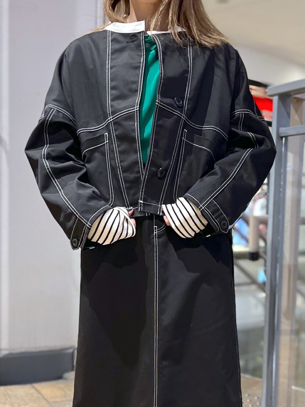 ブラック系のブルゾン、グリーン系のTシャツ/カットソー、ブラック系のスカートを着用したレディースの春コーディネートの2枚目の写真