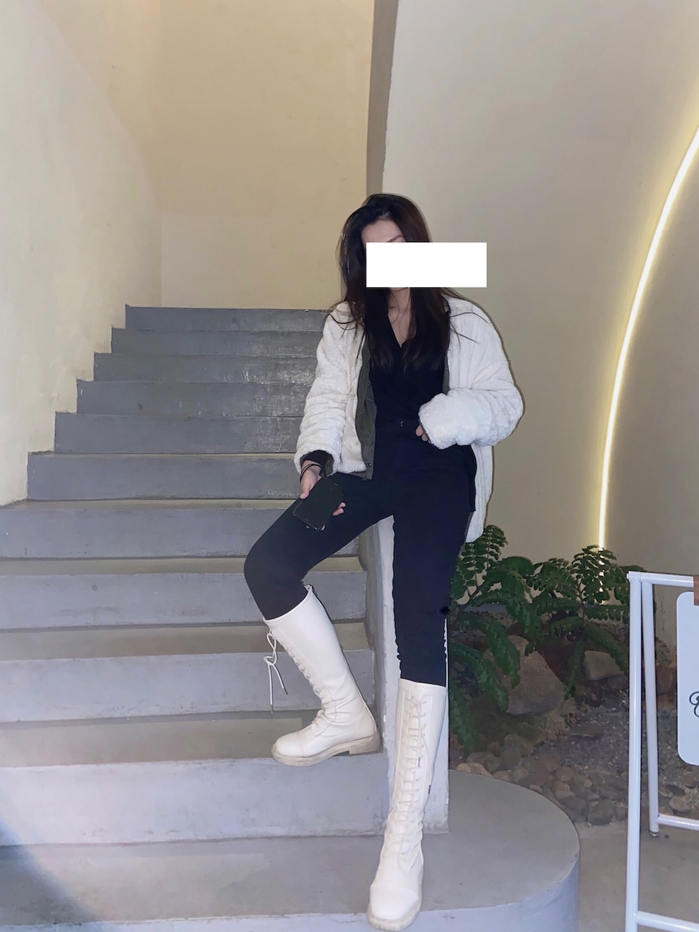 ホワイト系のジャケット/アウター、ブラック系のニット/セーター、ブラック系のチノパンツを着用したレディースの秋コーディネートの2枚目の写真