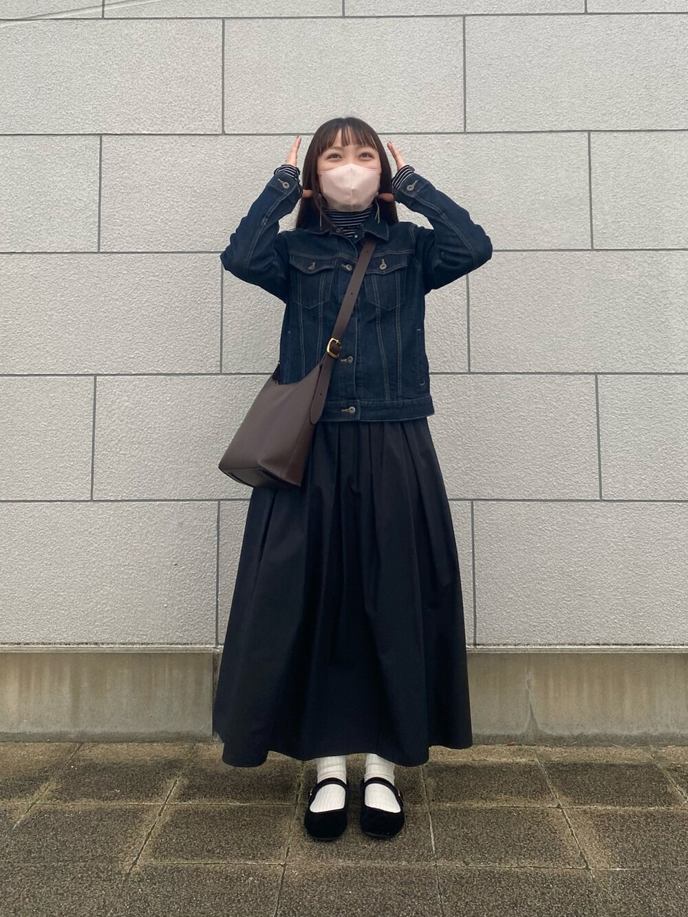 ブルー系のデニムジャケット、ブラック系のTシャツ/カットソー、ブラウン系のショルダーバッグを着用したレディースの秋コーディネートの2枚目の写真