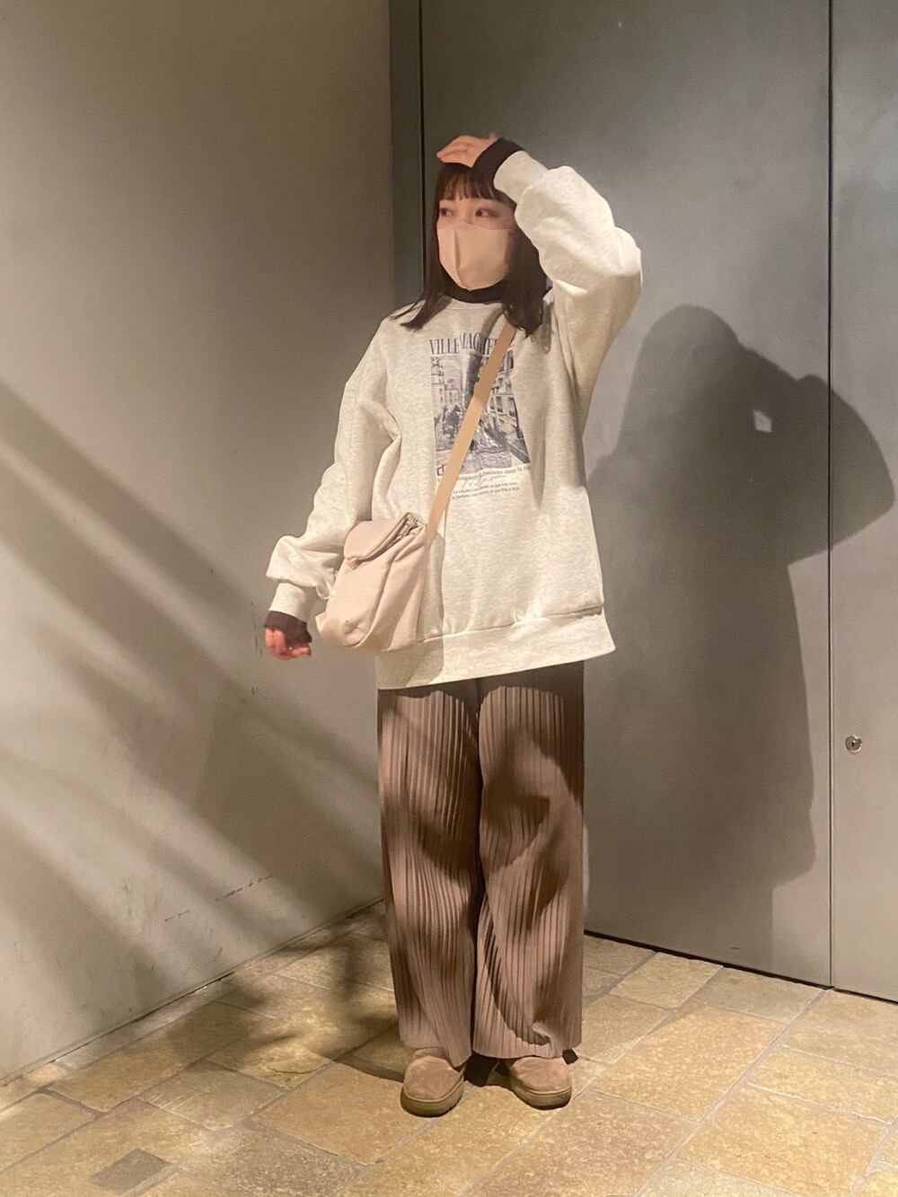 ホワイト系のスウェット、ブラウン系のTシャツ/カットソー、ブラウン系のパンツを着用したレディースの冬コーディネートの3枚目の写真