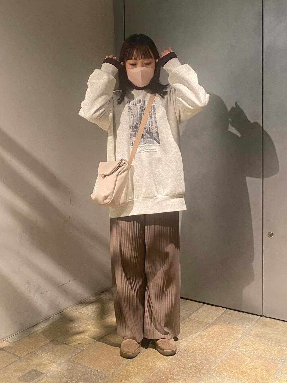 ホワイト系のスウェット、ブラウン系のTシャツ/カットソー、ブラウン系のパンツを着用したレディースの冬コーディネートの2枚目の写真