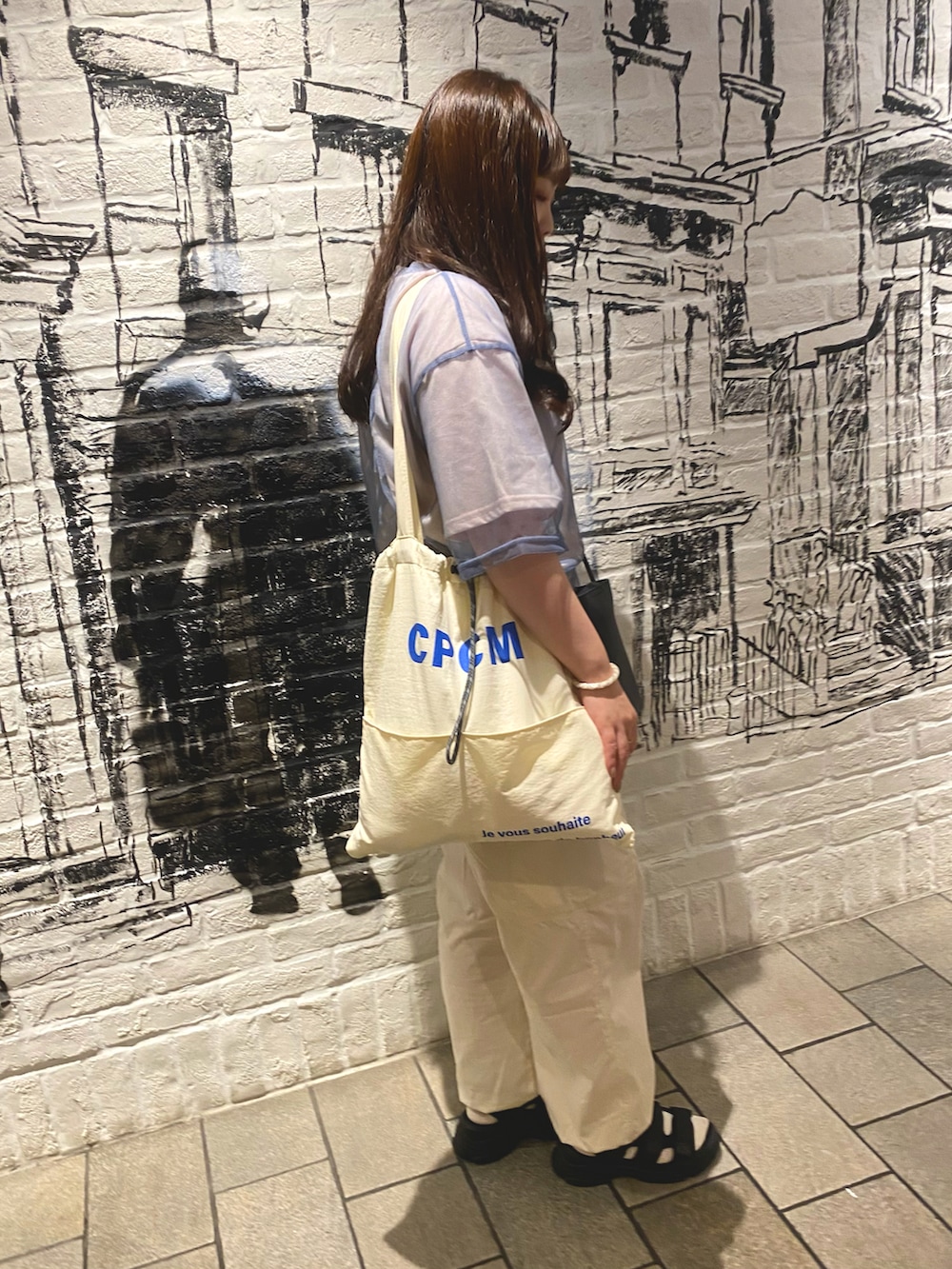 ピンク系のTシャツ/カットソー、ホワイト系のトートバッグ、ブラック系のショルダーバッグを着用したレディースの夏コーディネートの2枚目の写真