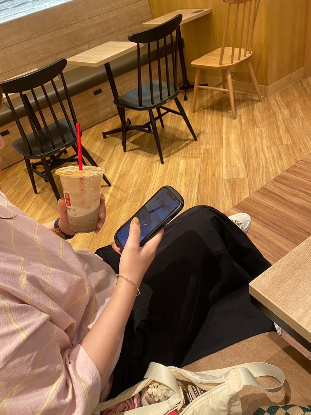 ピンク系のTシャツ/カットソー、ブラック系のスカート、ホワイト系のスニーカーを着用したレディースの秋コーディネートの2枚目の写真