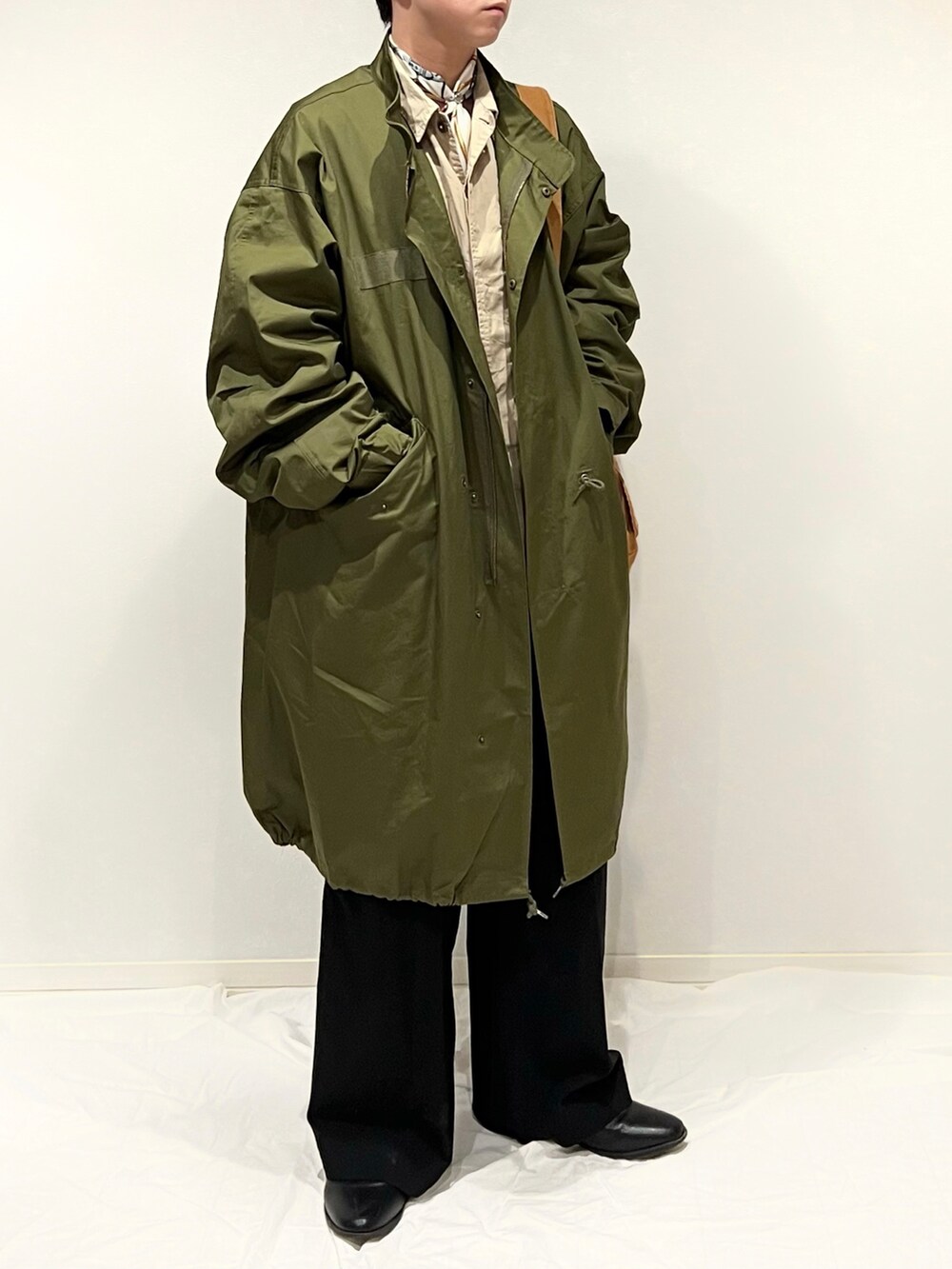 グリーン系のミリタリージャケット、ブラウン系のショルダーバッグ、ブラック系のスラックスを着用したメンズの秋コーディネートの2枚目の写真