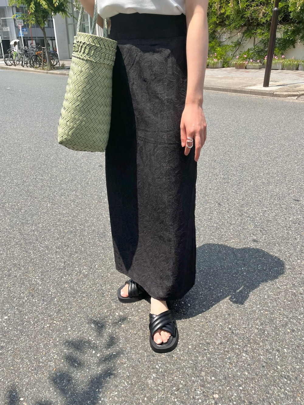 ブラック系のスカート、ホワイト系のTシャツ/カットソー、ベージュ系のハットを着用したレディースの夏コーディネートの5枚目の写真
