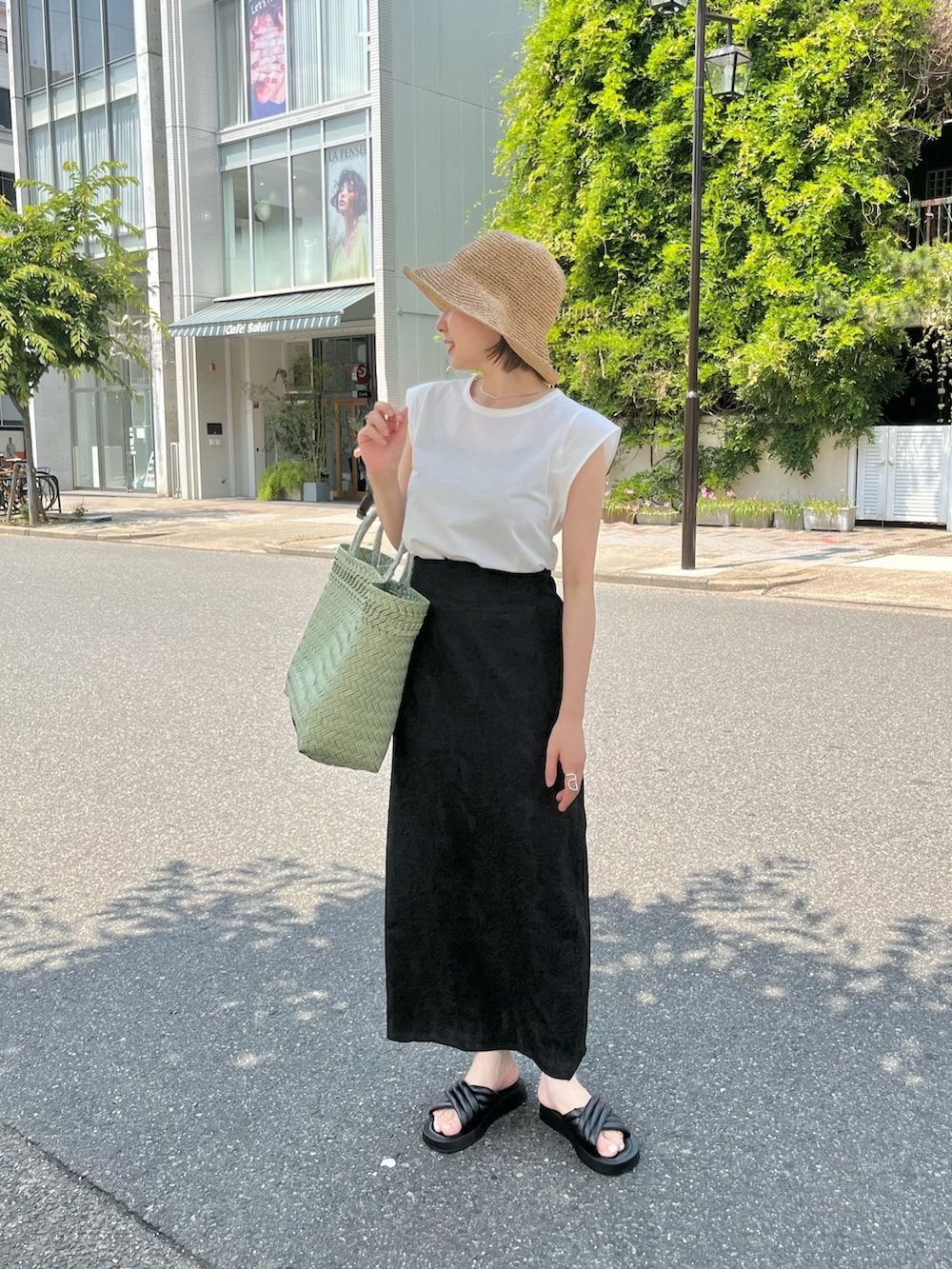 ブラック系のスカート、ホワイト系のTシャツ/カットソー、ベージュ系のハットを着用したレディースの夏コーディネートの2枚目の写真