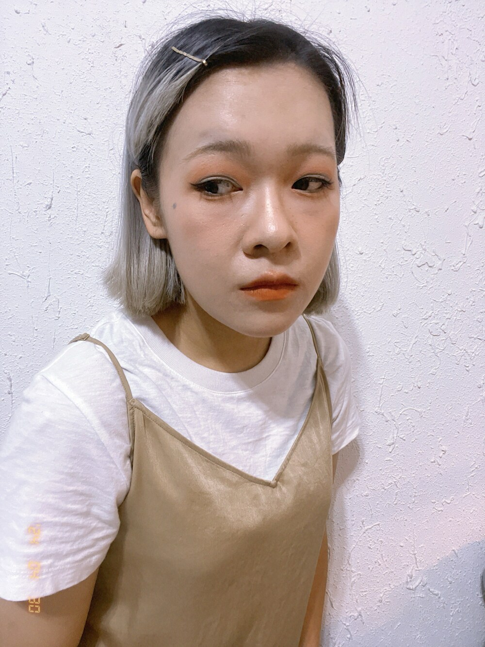 ベージュ系のジャンパースカート、イエロー系のスニーカー、ホワイト系のTシャツ/カットソーを着用したレディースの春コーディネートの2枚目の写真