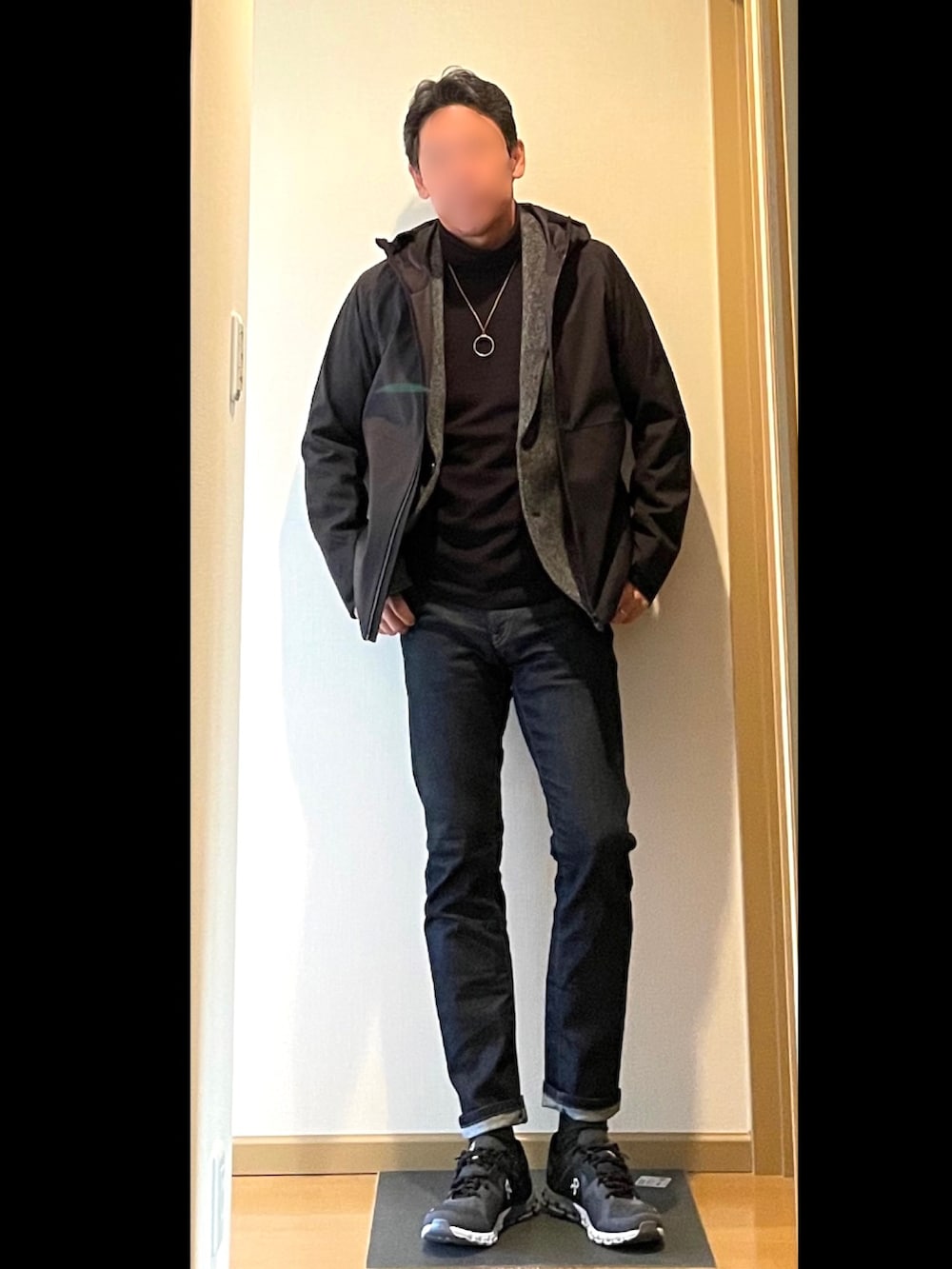 ブルー系のデニムパンツ、ブラック系のスニーカー、ブラック系のトップスを着用したメンズの秋コーディネートの2枚目の写真