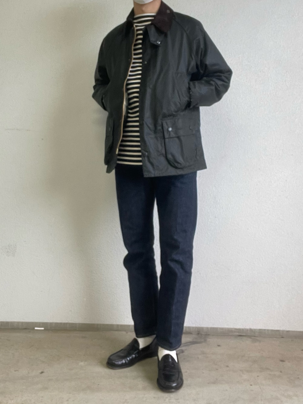 グリーン系のブルゾン、ブルー系のデニムパンツ、ブラック系のローファーを着用したメンズの冬コーディネートの2枚目の写真