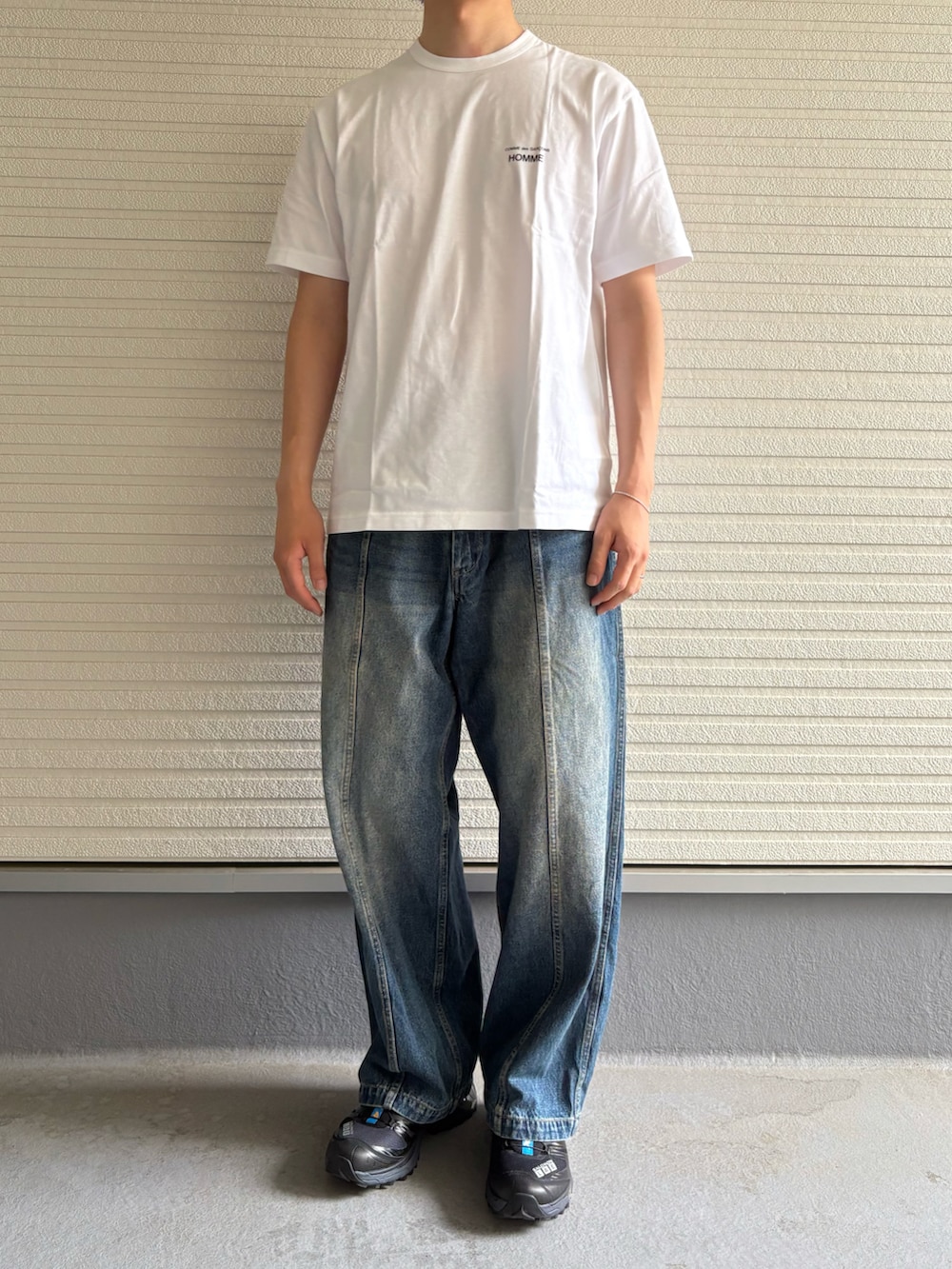 ホワイト系のTシャツ/カットソー、ブルー系のデニムパンツ、ブラック系のスニーカーを着用したメンズの夏コーディネートの3枚目の写真