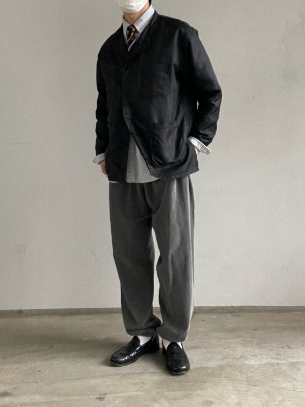 ブラック系のトップス、グレー系のスウェットパンツ、ブラック系のローファーを着用したメンズの冬コーディネートの2枚目の写真