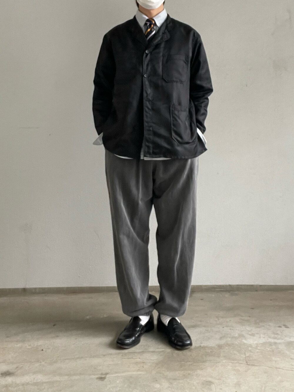 ブラック系のトップス、グレー系のスウェットパンツ、ブラック系のローファーを着用したメンズの冬コーディネートの3枚目の写真