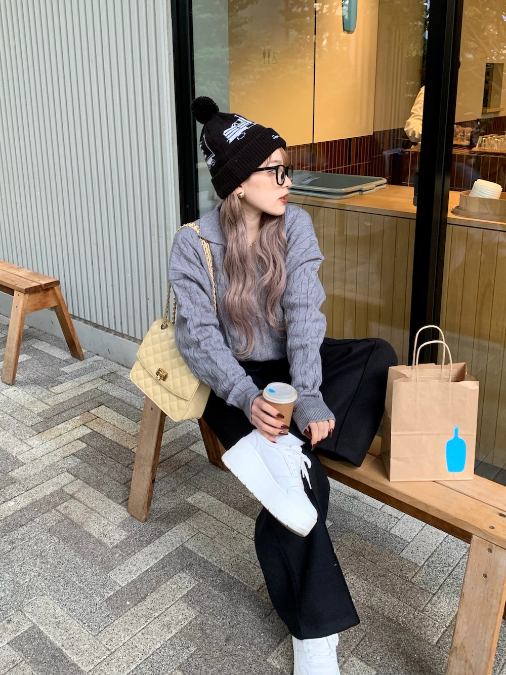 ブラック系のスラックス、ベージュ系のショルダーバッグ、ホワイト系のスニーカーを着用したレディースの冬コーディネートの2枚目の写真