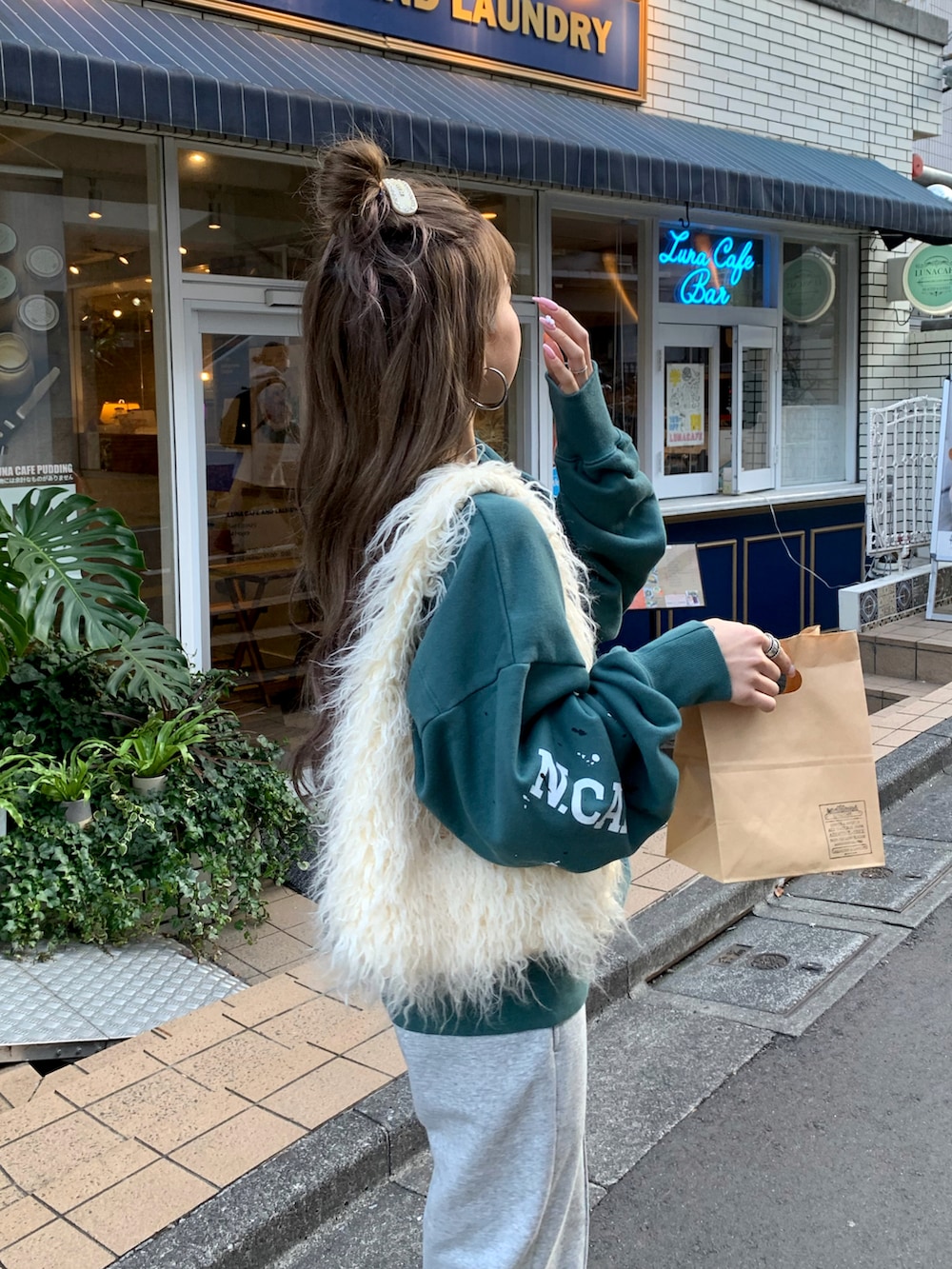 ホワイト系のハンドバッグ、グレー系のスウェットパンツ、ホワイト系のスニーカーを着用したレディースの冬コーディネートの2枚目の写真