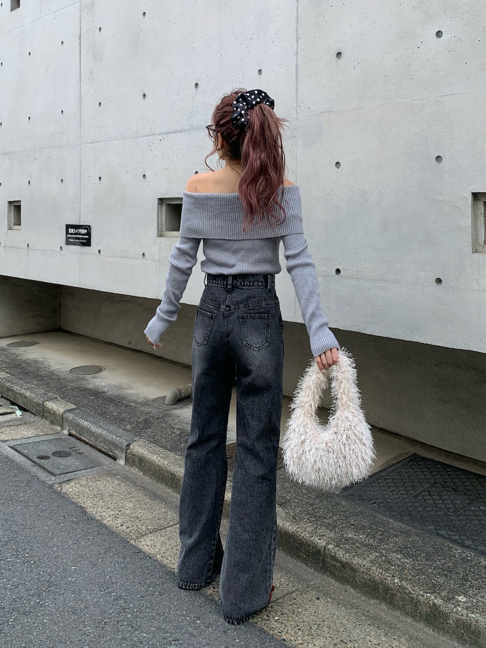 グレー系のニット/セーター、ブラック系のデニムパンツ、レッド系のパンプスを着用したレディースの秋コーディネートの2枚目の写真