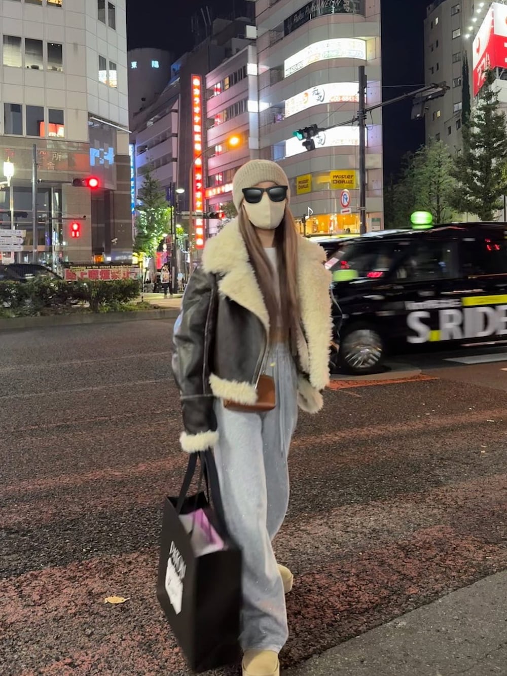 ブラウン系のムートンコート、ブラック系のスウェットパンツ、ベージュ系のブーツを着用したレディースの冬コーディネートの2枚目の写真