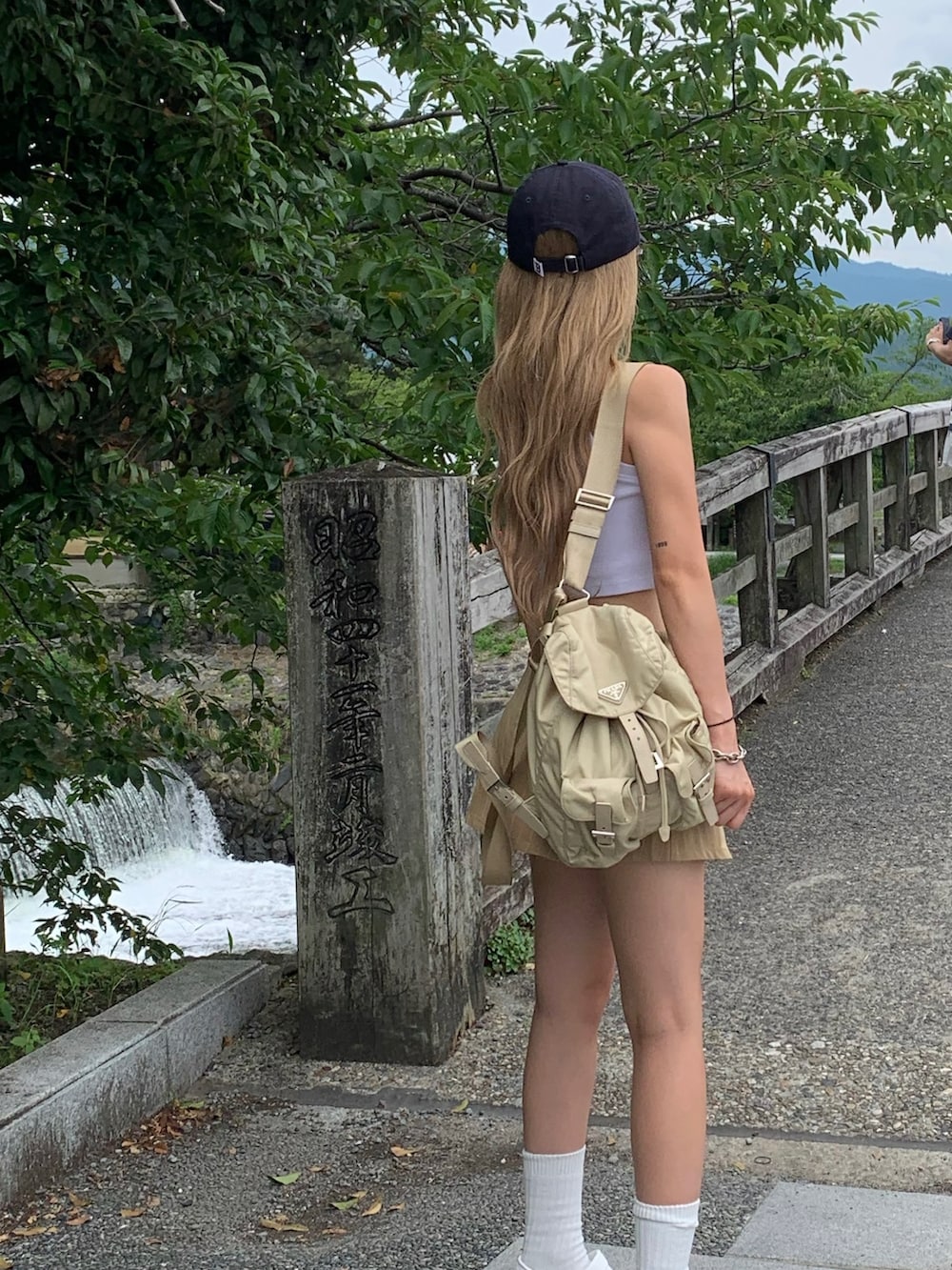 ホワイト系のタンクトップ、ベージュ系のスカート、ホワイト系のサンダルを着用したレディースの夏コーディネートの2枚目の写真