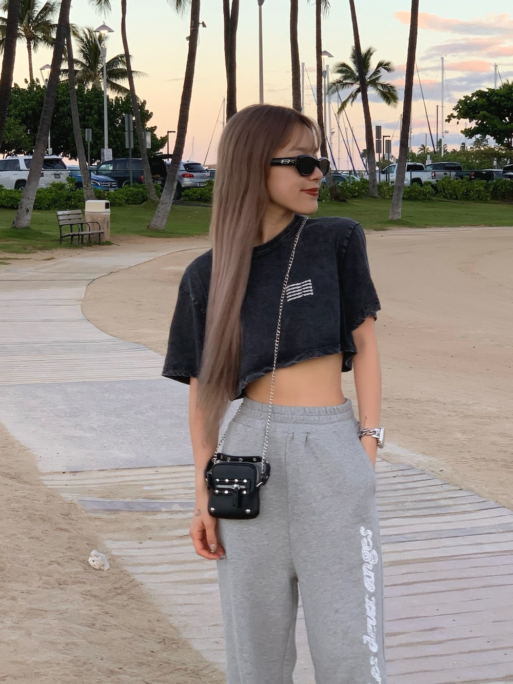 グレー系のスウェットパンツ、ピンク系のスニーカー、ブラック系のトップスを着用したレディースの春コーディネートの2枚目の写真