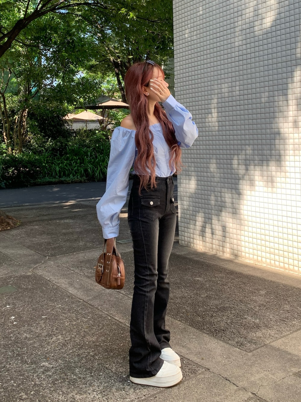 ブルー系のシャツ/ブラウス、ブラック系のデニムパンツ、ブラウン系のボストンバッグを着用したレディースの秋コーディネートの2枚目の写真