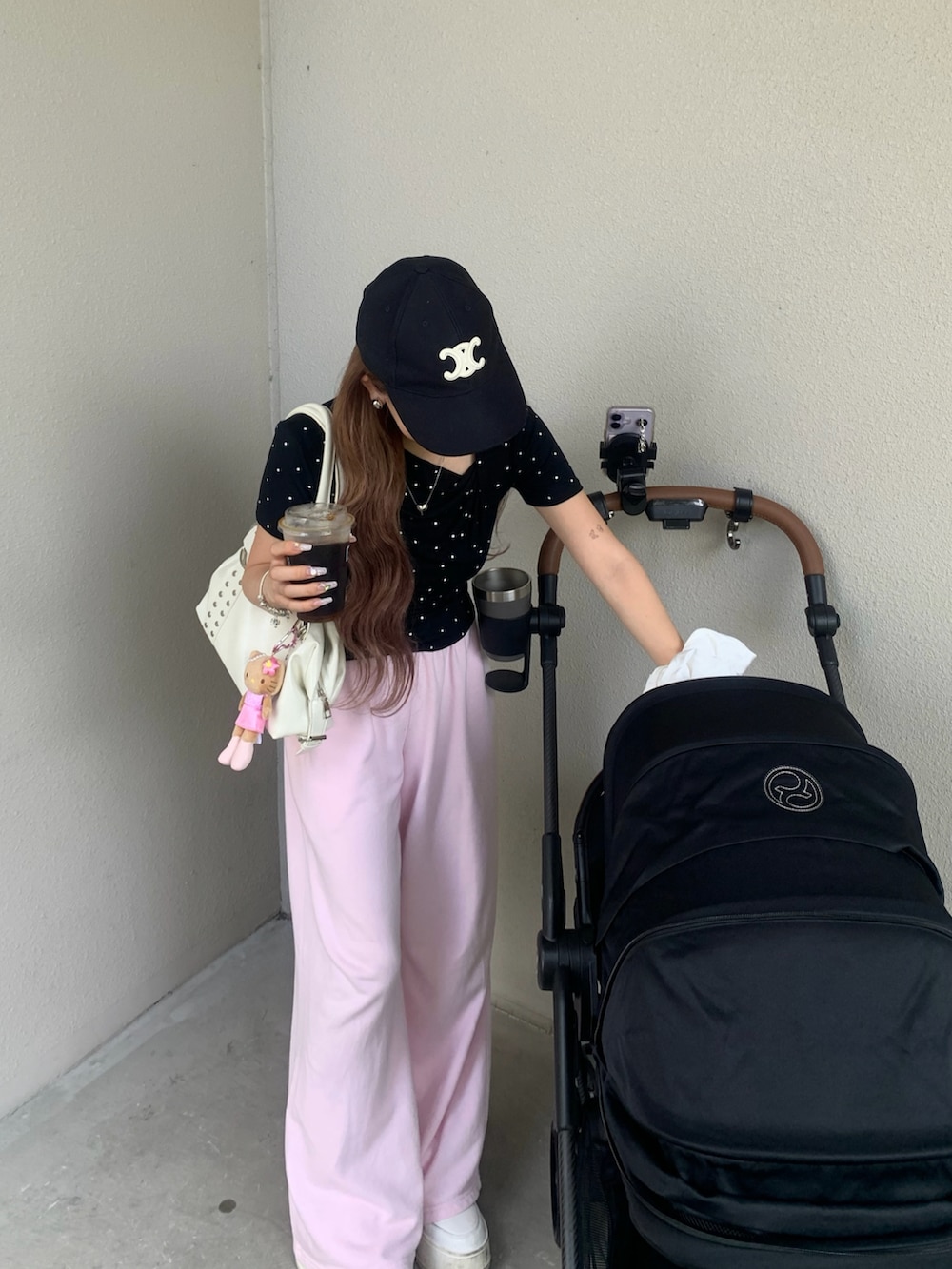ブラック系のTシャツ/カットソー、ピンク系のスウェットパンツ、ホワイト系のハンドバッグを着用したレディースの夏コーディネートの2枚目の写真