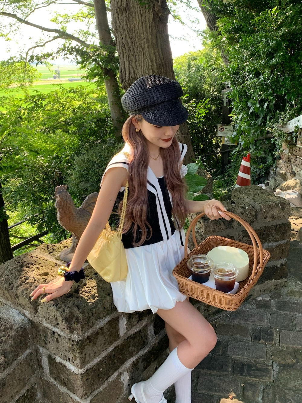 ホワイト系のスカート、ブラック系のトップス、ブラック系のキャスケットを着用したレディースの夏コーディネートの2枚目の写真